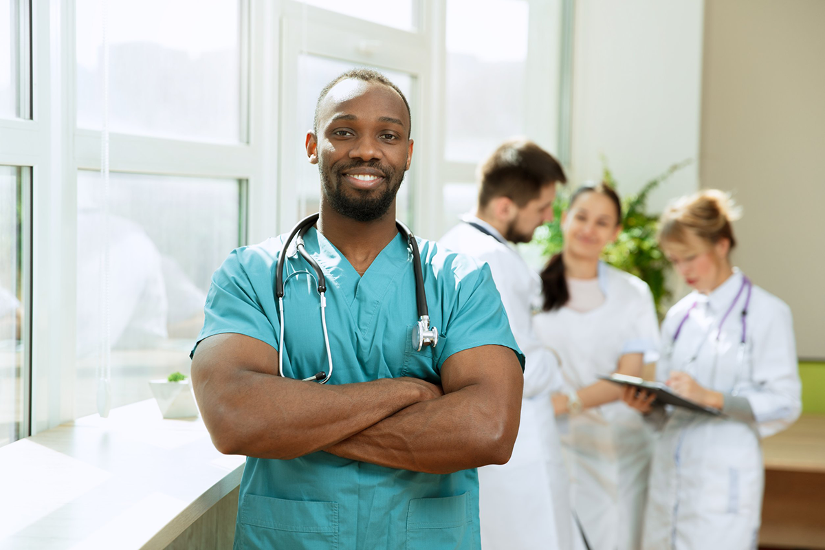 A male nurse with a group of doctors behind him